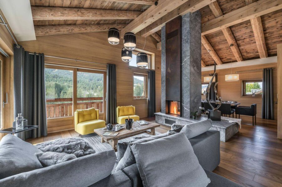 chalet-malorie-livingroom-fireplace-openplan-diningroom-balcony-scenicviews-luxury-alpine-retreat-megeve