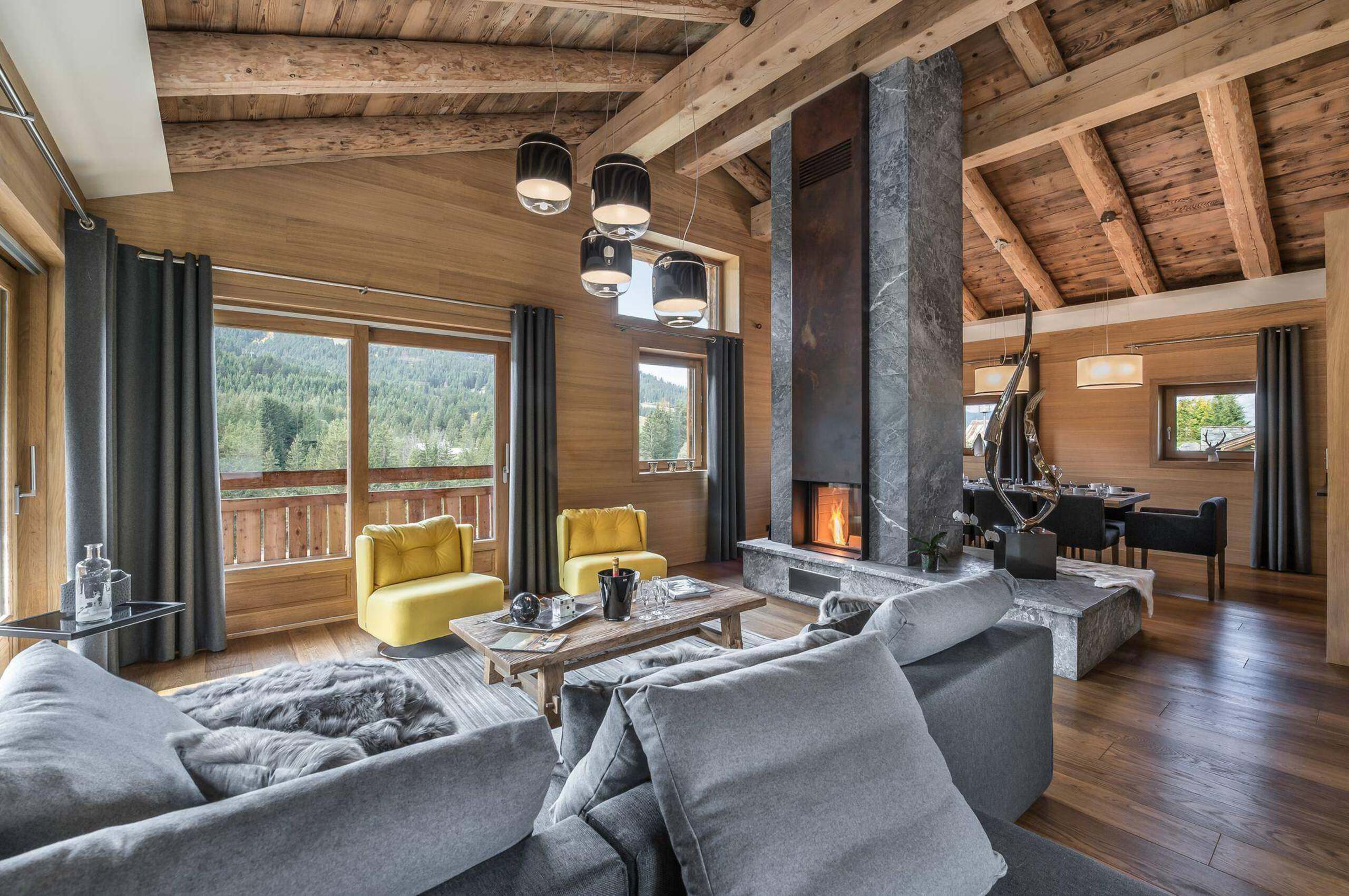 chalet-malorie-livingroom-fireplace-openplan-diningroom-balcony-scenicviews-luxury-alpine-retreat-megeve