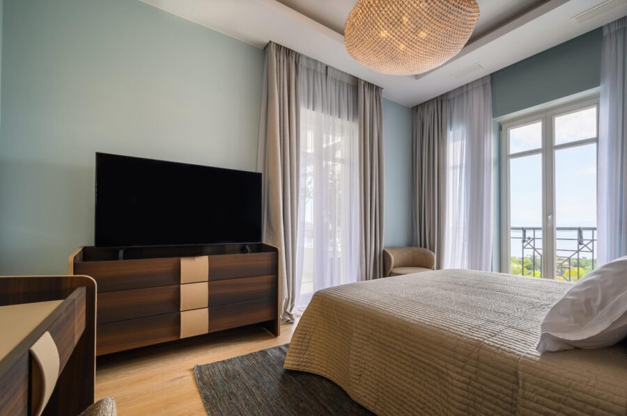 villa-dalida-bedroom-tv-balcony-sea-view-elegant-rental-retreat-luxury-crete