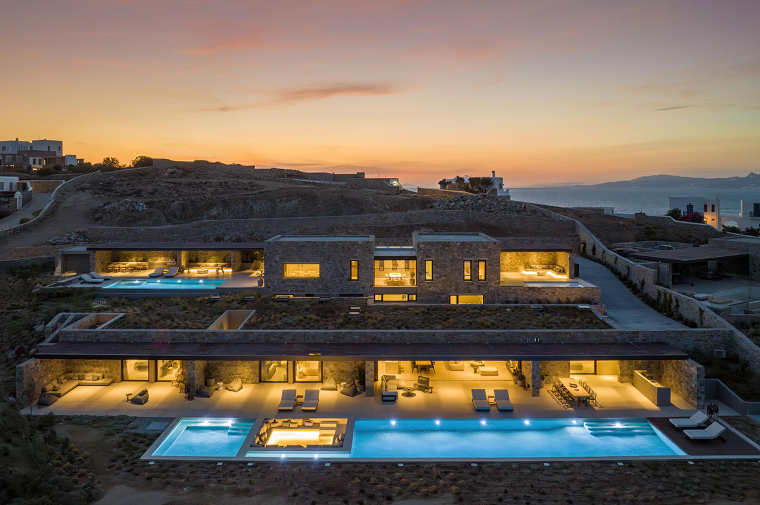 villa-lyra-exterior-nightime-luxury-mediterranean-rental-retreat-swimming-pool-terrace-sea-view-mykonos